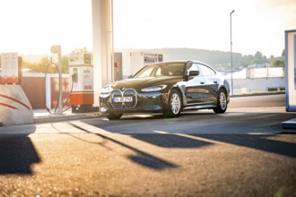 BMW at a gas station at sunset in an urban area, BMW i7 electric car, Deer e-Carsharing, Calw,