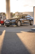 BMW at a gas station with incoming sunlight, BMW i7 electric car, Deer e-Carsharing, Calw, Germany