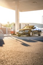 BMW at a gas station during sunset, BMW i7 electric car, Deer e-Carsharing, Calw, Germany