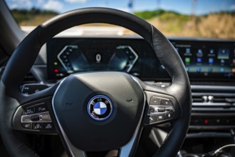 The modern steering wheel of a car with tech-heavy dashboard and display, BMW i7 electric car, Deer