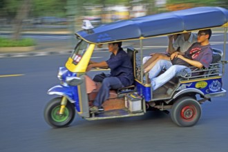 Tourists in a three-wheeled tuk tuk taxi, blurred, Bangkok, Thailand, December 2002, vintage,