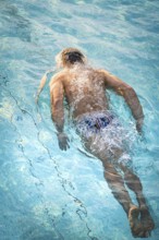 A swimmer dives through the pool and creates dynamic water splashes, Triathlon, Calw, Germany