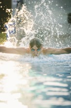 A dynamic moment of a swimmer in the pool with splashes of water in the air, Triathlon, Calw,