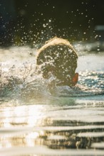 A swimmer moves energetically through the water in sunlight, Triathlon, Calw, Germany