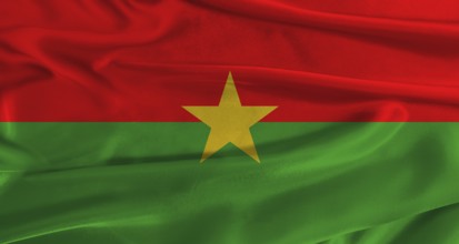 Flag of Burkina Faso with fabric textured background. Close up of National flag of Burkina Faso