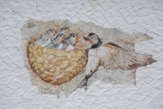 Swallow feeding her young in the nest, a painting on a farmhouse, Morschreuth, Upper Franconia,