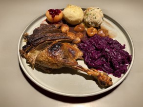 Plate with goose leg, goose breast, red cabbage, red cabbage, marenen, bread dumplings, raw potato