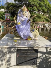Statue sculpture of Hindu deity Saraswati stands in crater lake in crater of extinct volcano sacred