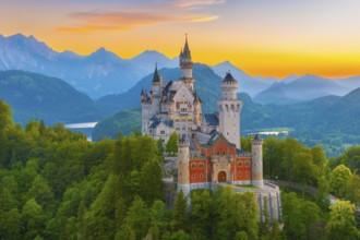Majestic Neuschwanstein Castle against an alpine backdrop at sunset with plenty of nature and