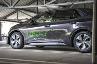 Black car sharing car with LEASER branding on side view in parking garage, Cupra electric car,