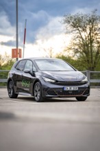 A Cupra vehicle is parked outside in front of a cloudy sky, gives a modern and stylish impression,