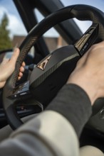 Looking at a Cupra steering wheel while a person is driving the car and conveys a comfortable