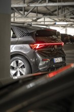 Rear view of a modern black car with distinctive LED rear lights in garage, Cupra electric car,