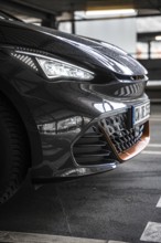 Close-up of a modern black car in underground garage with sporty design, Cupra electric car, e-car