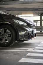 Close up of a black car in an urban parking lot from the front, electric car Cupra, e-car sharing,