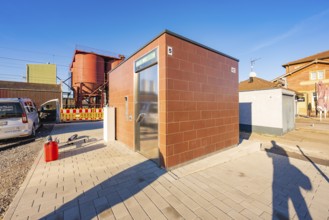 Modular brick-colored building next to parked vehicle, Weil der Stadt railway station, Germany