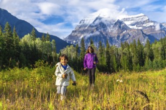 Mother and son are hiking in a meadow near mount robson, enjoying the stunning view of the canadian