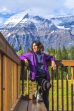 Female hiker relaxing and enjoying the majestic view of mount robson, the highest peak in the
