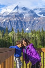 Mother and son are enjoying breathtaking views of mount robson, the highest peak in the canadian
