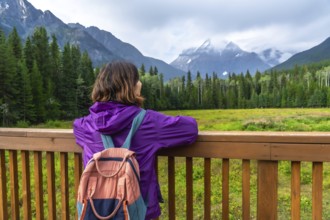 Female hiker with backpack enjoying the scenic view of mount robson, the highest peak in the