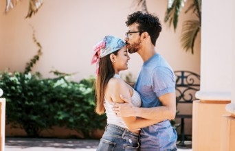 Cute couple embracing the boyfriend kisses the girl forehead. Portrait of beautiful couple in love.