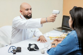 Doctor measuring temperature with infrared gun to female patient, Doctor taking temperature to