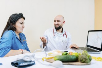 Smiling nutritionist explaining to a female patient, Nutritionist man talking to woman patient in