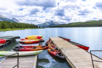 Colorful canoes and kayaks resting on a wooden dock invite exploration of maligne lake's pristine