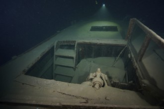 Diver examines a lediwreck, wreck of a lediship, ledi ship, cargo ship for mass freight, bulk