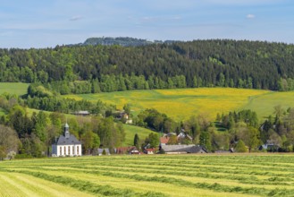 Church and houses in the village of Schwarzbach, in the back forest and blooming meadows, town of