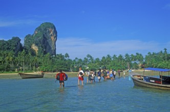 Tourists wade to their boat taxi that brings them back to Krabi, two years in front of the tsunami,
