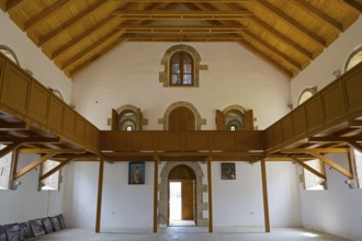 Spacious church interior with distinctive wooden ceiling and windows. Light flows through