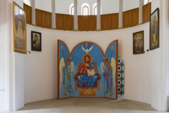 Iconostasis with central image of Christ and angels. Bright church surrounded by religious