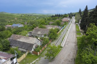 A quiet village with hills, wooded roads and scattered houses, view from the German Evangelical