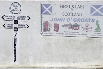 Wall panel with signs and distances at John O'Groats in Scotland, Great Britain