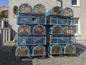 Stacked fishing baskets outside a building ready for fishing, Westray, Orkney Islands, Scotland,