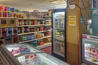 Small supermarket with fully stocked shelves and refrigerated products, shop on Westray Island,