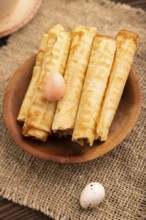 Waffles with caramel on brown wooden background and linen textile, cup of coffee, side view,