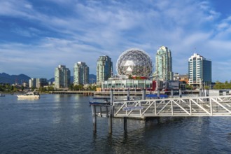 Modern buildings and science world are reflecting in the calm waters of false creek, vancouver,