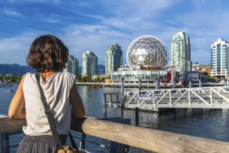Young woman tourist is enjoying the cityscape of vancouver, british columbia, with science world