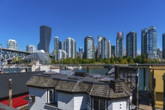 Granville island market with vancouver skyline rising in background on a sunny day, showcasing the