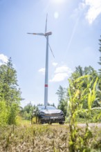 Car standing under a large wind turbine in sunny weather in a field, Deer E-Car Sharing, Cupra