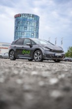 Car in front of a modern tower in a parking lot, deer e-car sharing, Cupra electric car, Böblingen,