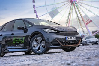 Modern cars in front of a big Ferris wheel at a trade show, Deer E-Car Sharing, Cupra electric car,