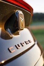 Close-up of emblem on black car with focus on details, Deer e-car sharing, Cupra electric car,
