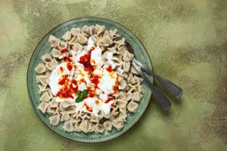 The dish features a generous serving of Turkish dumplings topped with velvety yogurt and a drizzle