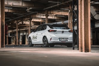 Rear view of a white car sharing car in an urban industrial building, Deer E-Car Sharing,