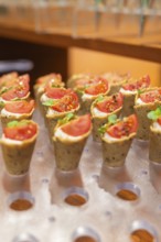 Small snacks with tomatoes and herbs presented on stylish pastries, Christmas party Dekra