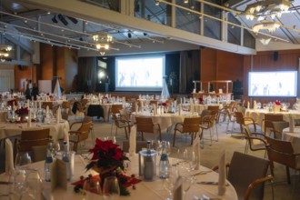 An elegant event room with set round tables and festive lighting, Christmas party Dekra