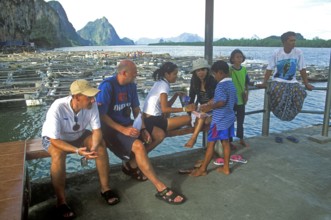 Young boy in the stilt village of Ko Pannyi in Phangnga Bay near Ko Phuket selling souvenirs to